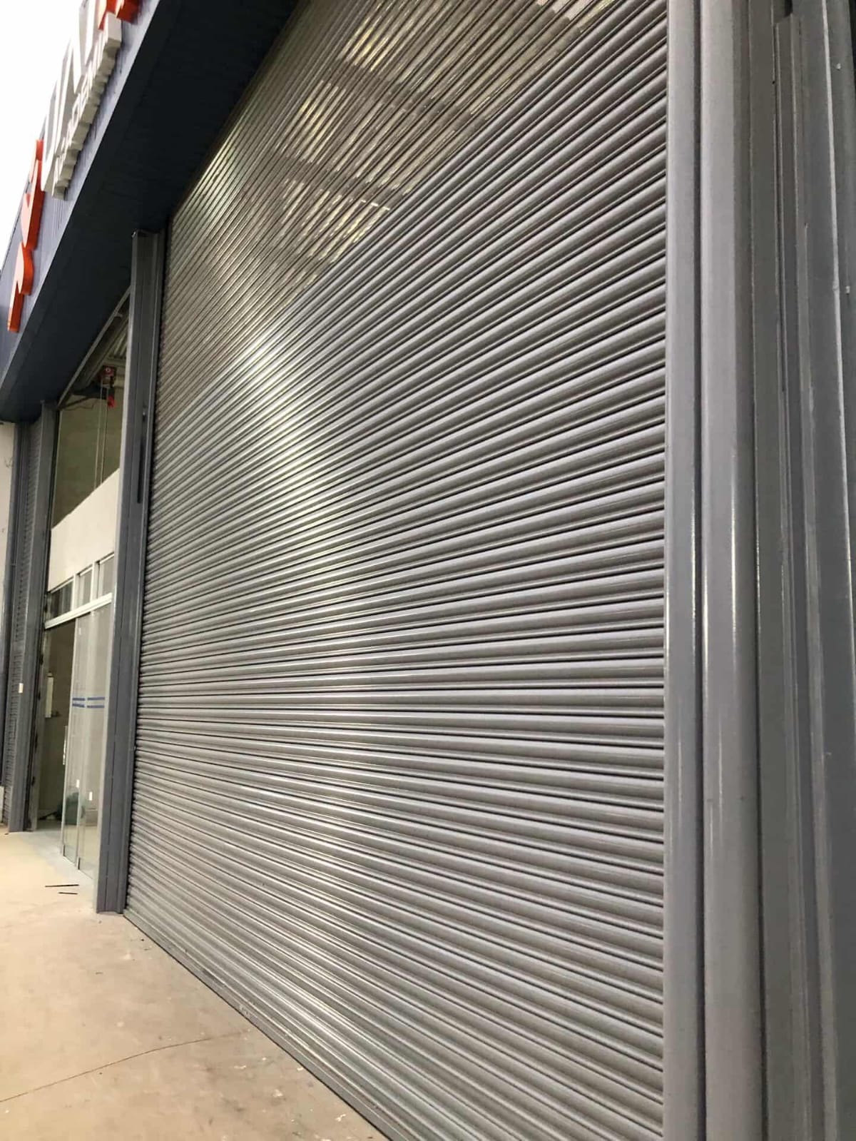 Portas de enrolar em fachada iluminada à noite