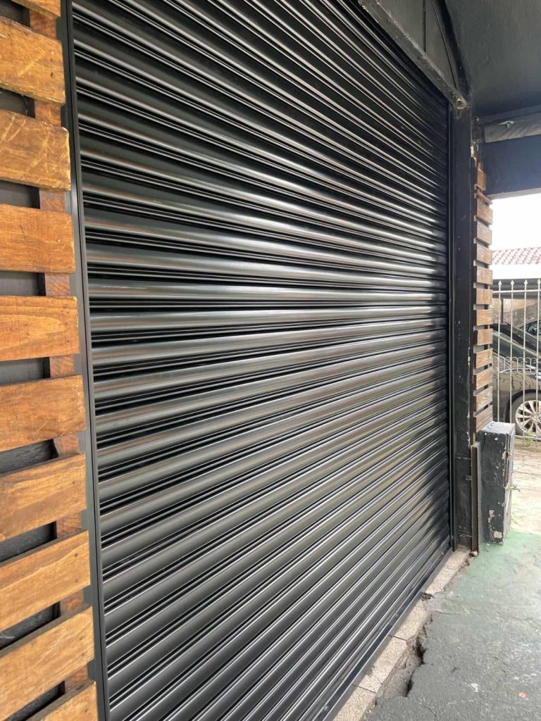 Porta de enrolar preta com ripado de madeira